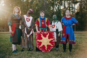 Hubris stands in the center surrounded by his squires and retainers.